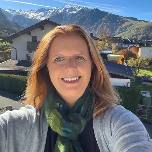 Tammy, founder of Austria Wanderlust—the Austria travel guide—on a balcony overlooking the Kitzsteinhorn glacier in Austria