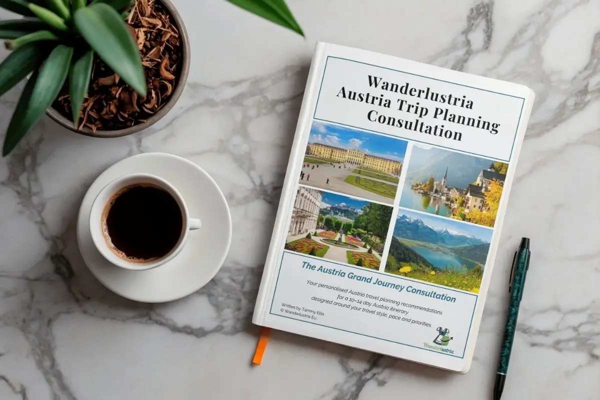 The Austria Travel Planning Consulation Guide on a marble table next to a coffee and pen
